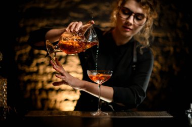 Seksi bayan barmen nazikçe bardağa doldurur.