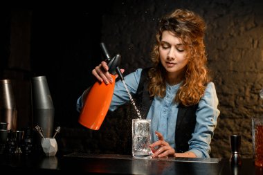 Kadın barmen elinde portakal suyu tutuyor ve suyu döküyor.