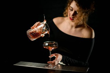 Karanlık odadaki seksi barmen kız kadehini yavaşça bardağa dolduruyor.