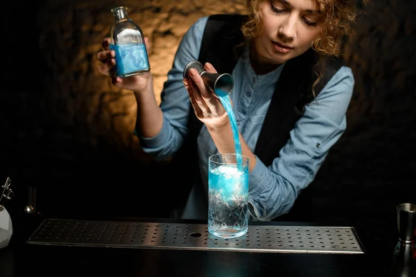 Kadın barmen nazikçe Jigger 'dan soğuk su bardağına su döker.