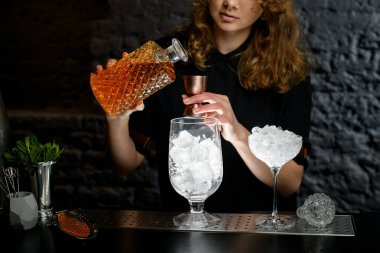 Kadın barmen sürahide içki doldurur..