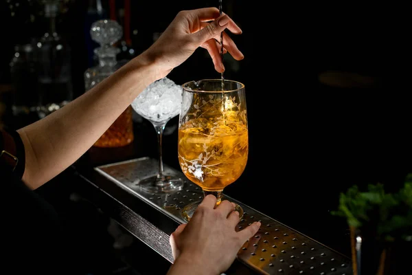 Primer plano de la mano de la mujer que mezcla cóctel alcohólico en taza de mezcla — Foto de Stock