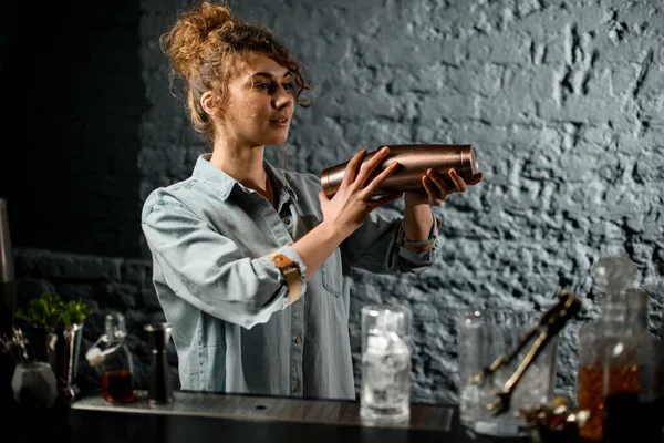 Jovem bartender mulher profissional detém agitador de metal e agita-lo . — Fotografia de Stock