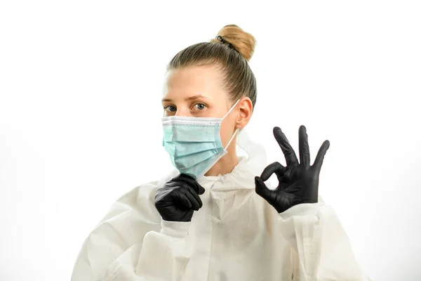 Jeune femme blonde en costume de protection et gants montre ok signe — Photo