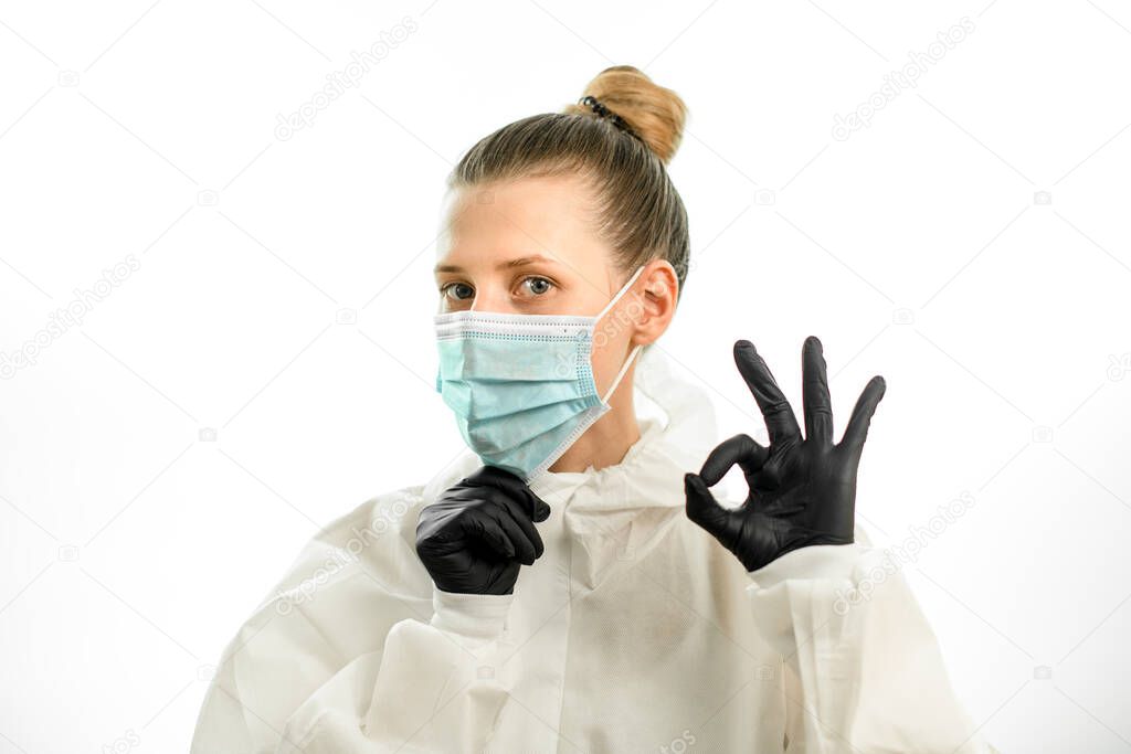 young blonde woman in protective suit and gloves shows ok sign