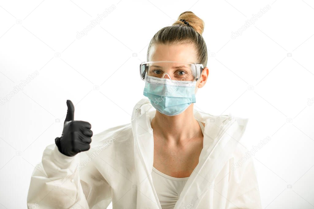 young blonde woman in protective suit with goggles and gloves showing thumbs up sign