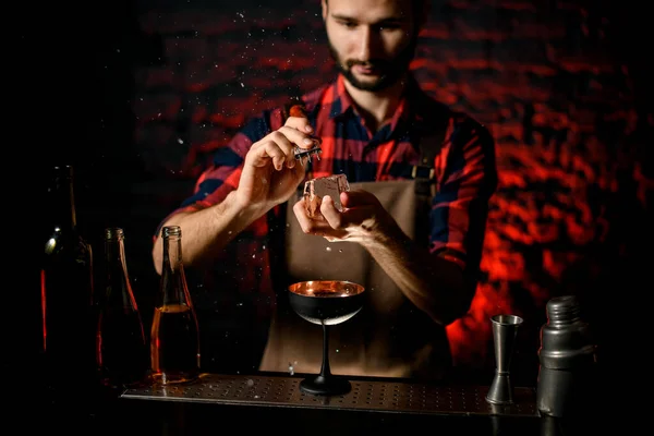 Profesjonalny barman trzyma duży kawałek lodu i łamie go — Zdjęcie stockowe