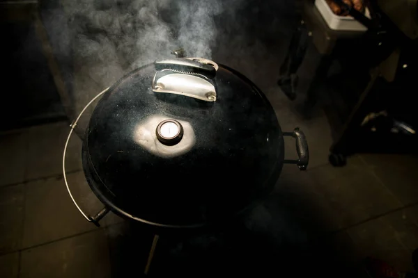 A carne é grelhada em churrasco redondo preto especial com tampa fechada — Fotografia de Stock
