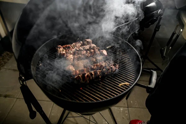 Vista de carne na grelha que cozinheiro masculino profissional voltas precisas usando pinças . — Fotografia de Stock