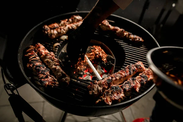 丸いバーベキューグリルで肉の炒め物を眺めます. — ストック写真