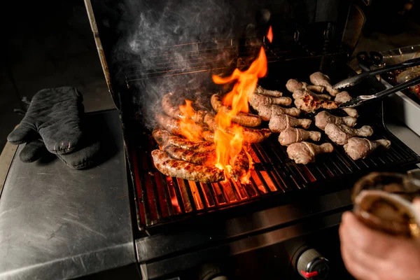 男の料理人がトントンでまっすぐに焼き上げる焼き肉を眺め — ストック写真