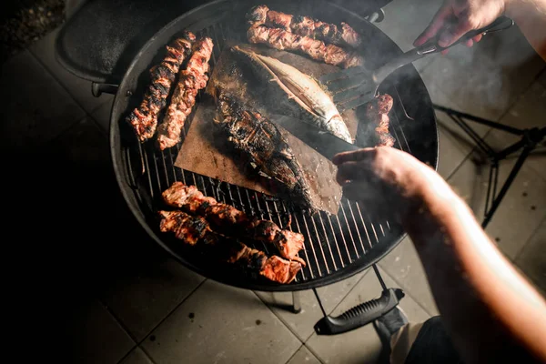 焼き肉や魚をまっすぐにする料理人の手の上の眺め — ストック写真