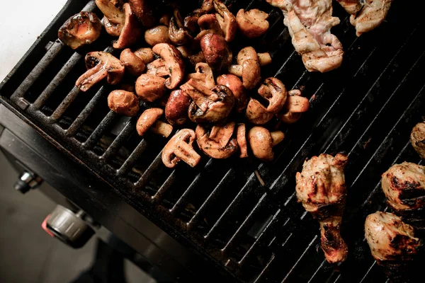 Vista superior na grelha com cogumelos fritos e pedaços de carne . — Fotografia de Stock