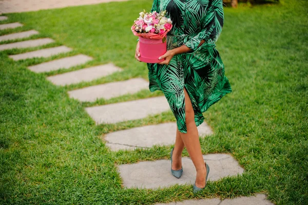 Caminante mujer con caja redonda rosa de flores en sus manos . — Foto de Stock