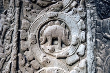 sculpted stone depicting a dinosaur at the ancient Ta Prohm temple at Angkor Wat, Siem Reap, Cambodia. clipart