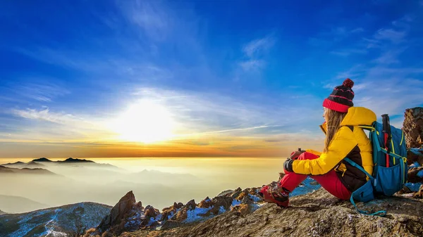 Jeune femme assise sur la colline des hautes montagnes au coucher du soleil . — Photo