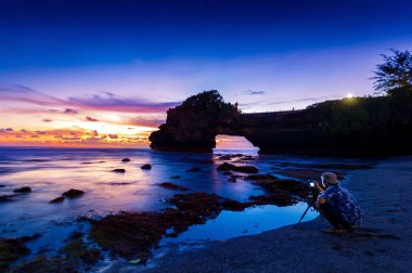 kamera ve Tanah çok tapınak gün batımında, Bali Endonezya tripod ile profesyonel fotoğrafçı.