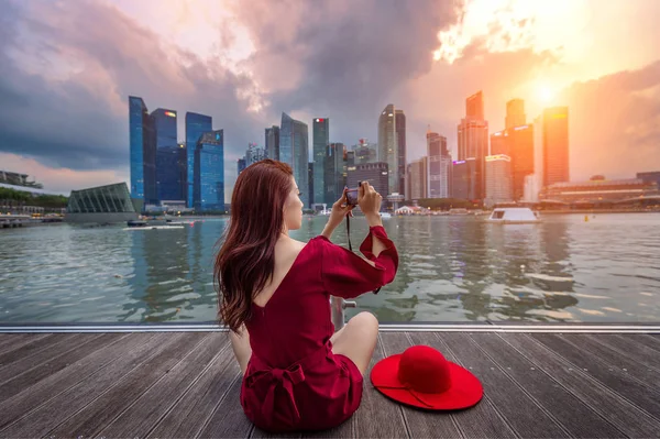 Mujer joven tomar una foto en Singapur . — Foto de Stock