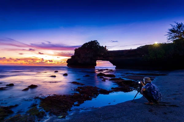 Professionell fotograf med kamera och stativ i Tanah Lot Tempel vid solnedgången, Bali i Indonesien. — Stockfoto