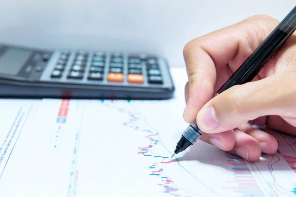 Businessman hand holding a pen working on document. Stock Picture