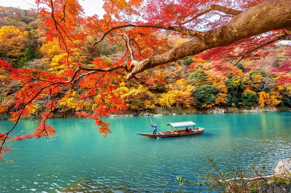 Boatman pateando el barco en el río. Arashiyama en la temporada de otoño a lo largo del río en Kyoto, Japón . — Foto de Stock