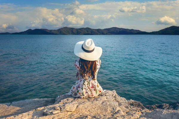 岩の上に座っていると海岸を見ている若い女性。ビンテージ トーン. — ストック写真