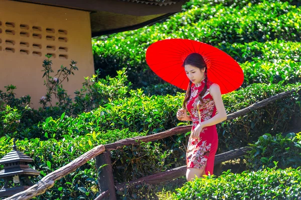 亚洲妇女穿中国传统礼服和红色雨伞 i — 图库照片