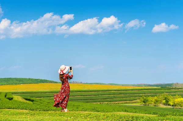 Femme debout sur l'herbe verte dans le champ de thé vert . — Photo