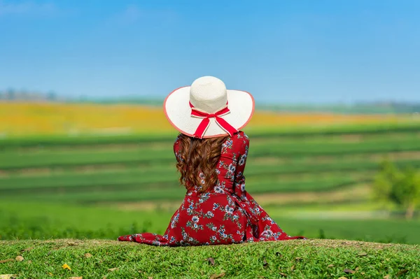Женщина сидит на зеленой траве на зеленом чайном поле . — стоковое фото