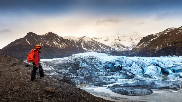 专业摄影师与相机和三脚架在冬季。在冰岛寻找冰川的专业摄影师. — 图库照片