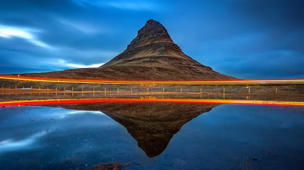 Kirkjufell Berge und Reflexion mit Autolicht, Island. — Stockfoto