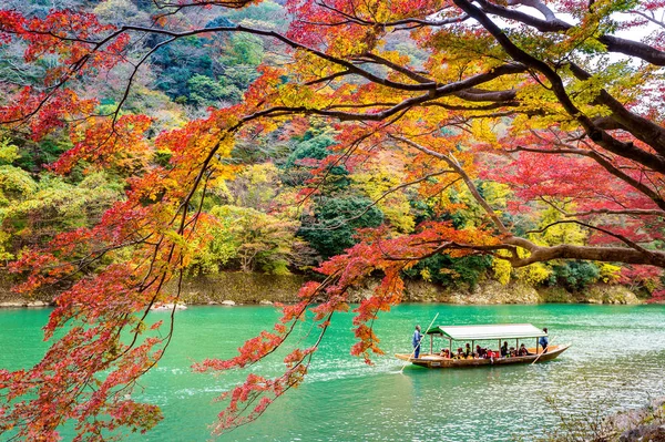 Bootsführer, der das Boot auf dem Fluss stößt. arashiyama im Herbst entlang des Flusses in Kyoto, Japan. — Stockfoto