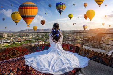 Otelde oturan güzel kız, Kapadokya, Türkiye 'de sıcak hava balonları arıyor..