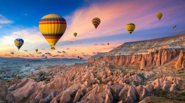 Goreme 'de gün batımında sıcak hava balonları ve Kızıl Vadi, Türkiye' de Kapadokya.