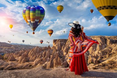 Kapadokya, Türkiye 'de ayakta duran ve sıcak hava balonları arayan güzel kız.