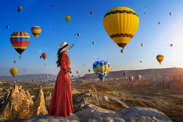 Mooi meisje staande en op zoek naar hete lucht ballonnen in Cappadocia, Turkije. — Stockfoto