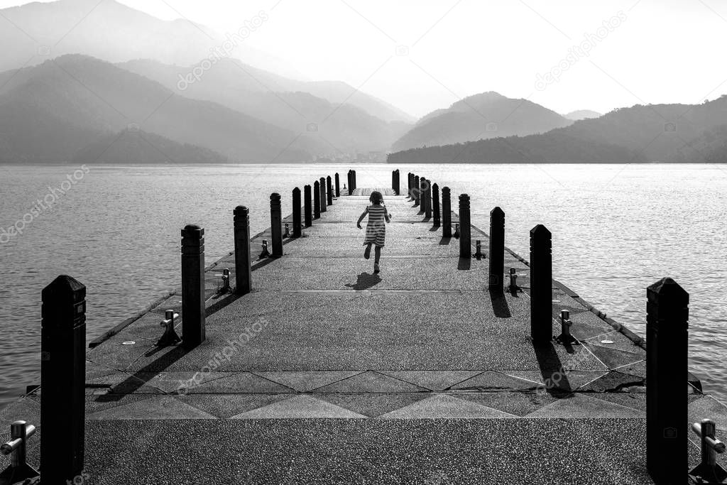 Black and white of Little girl running on pathway in Sun moon lake, Taiwan.