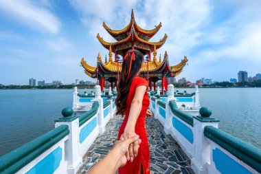 Kadın turistler erkeğin elini tutuyor ve onu Kaohsiung 'un Tayvan' daki ünlü turistik mekanına götürüyor..