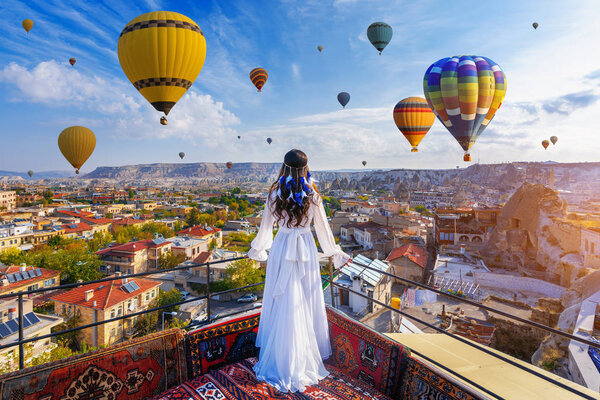 Девушка, стоящая в отеле и смотрящая на воздушные шары в турецком Каппесии
.