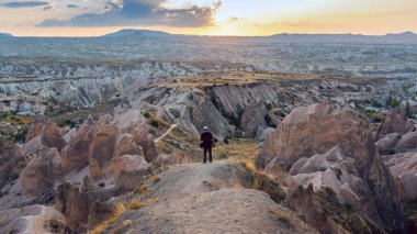 Kapadokya 'nın dağ manzarasında duran profesyonel fotoğrafçı.
