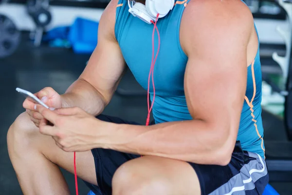 Hombre en el club deportivo usando smartphone —  Fotos de Stock