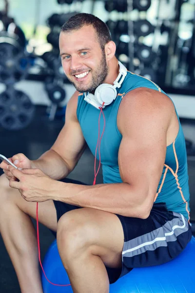 Hombre en el club deportivo usando smartphone —  Fotos de Stock