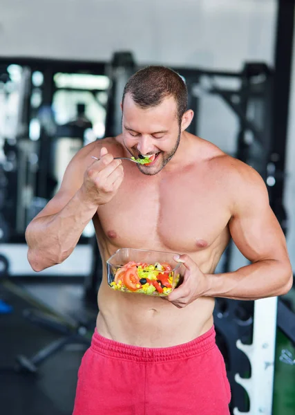 Hombre atlético con ensalada saludable en el gimnasio —  Fotos de Stock