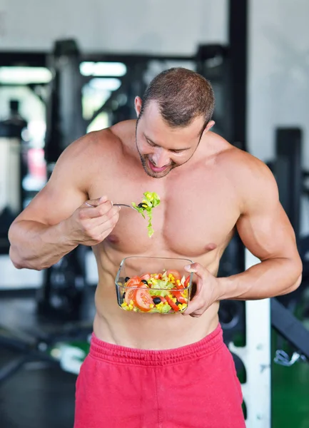 spor salonunda sağlıklı salata ile atletik erkek