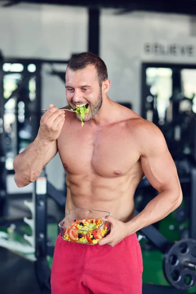 Hombre atlético con ensalada saludable en el gimnasio —  Fotos de Stock