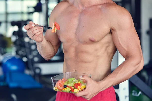 Hombre atlético con ensalada saludable en el gimnasio —  Fotos de Stock