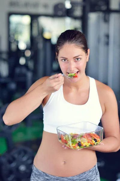 Spor salonunda salata yiyor atletik kadın — Stok fotoğraf