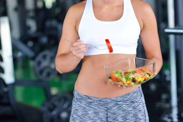 Spor salonunda salata yiyor atletik kadın — Stok fotoğraf