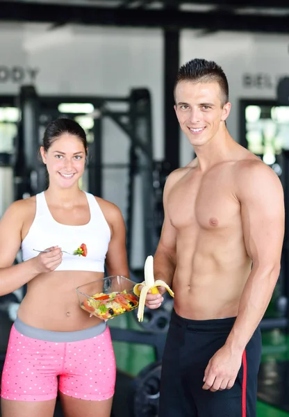 Par av bodybuilders äter på gym — Stockfoto