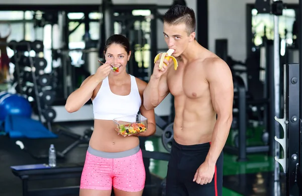 Par av bodybuilders äter på gym — Stockfoto